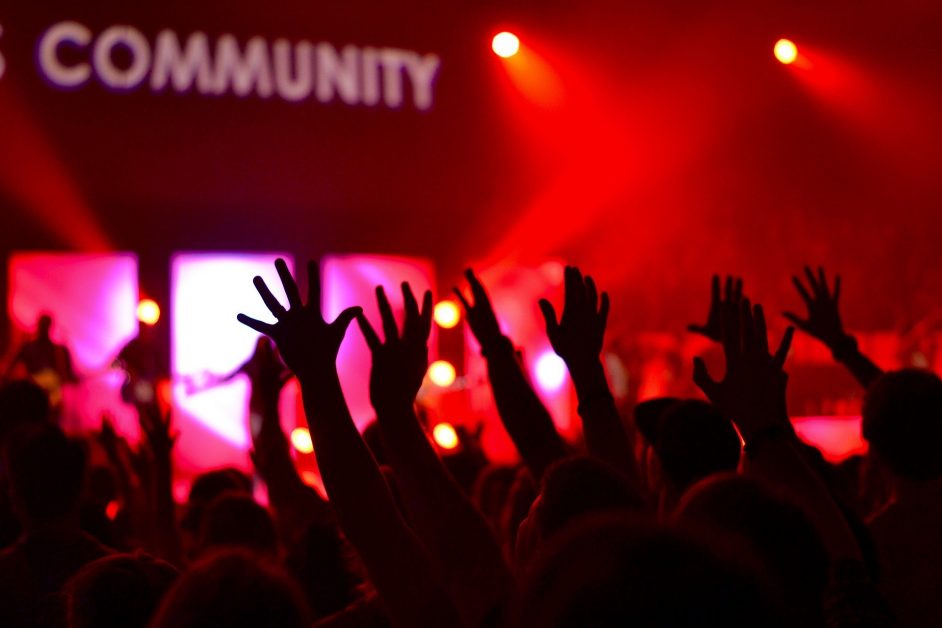 A group of people at a concert with the word "Community" above them is used in reference to classroom community